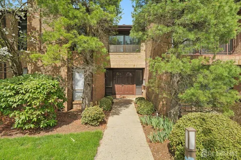a front view of a house with a yard and fountain in middle