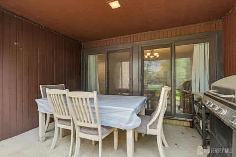 a view of a patio with table and chairs a barbeque with wooden floor and fence