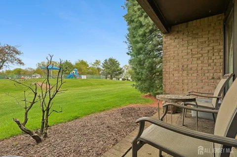 a patio with table and chairs and potted plants
