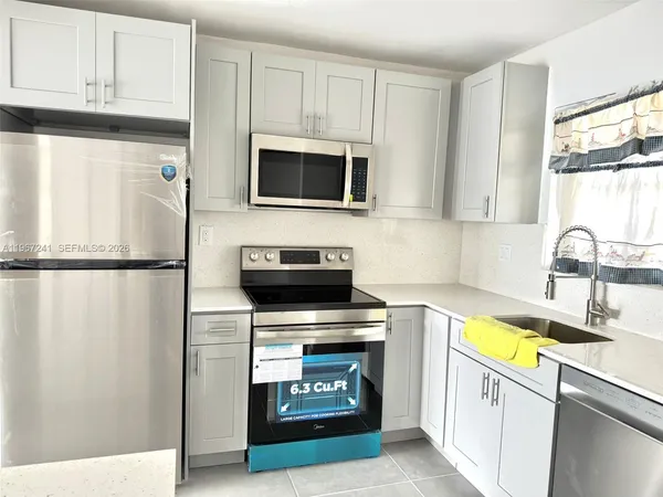 a kitchen with stainless steel appliances granite countertop a stove a microwave and a refrigerator