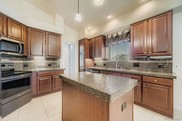 a kitchen with stainless steel appliances granite countertop a refrigerator and a sink