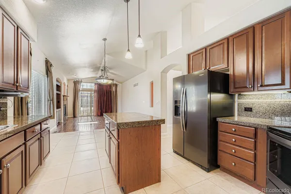 a kitchen with stainless steel appliances granite countertop a sink and a refrigerator