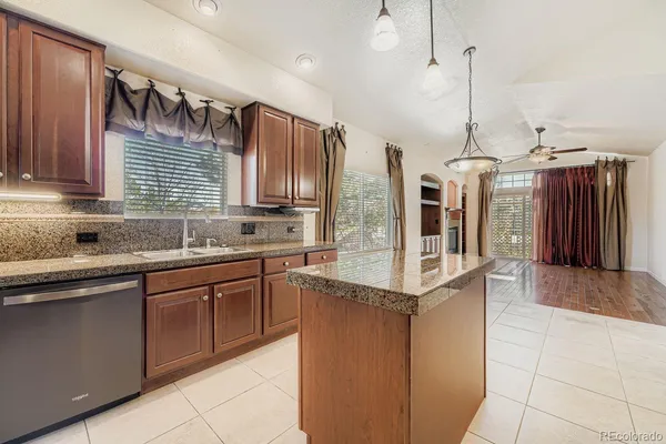a kitchen with stainless steel appliances granite countertop a sink a stove and a refrigerator