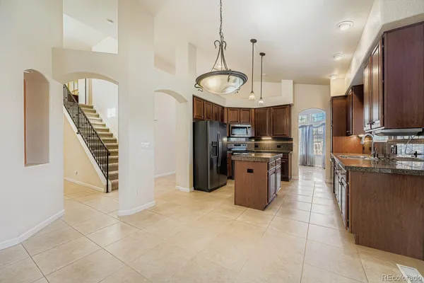 a kitchen with stainless steel appliances granite countertop a stove top oven a sink a counter space and cabinets