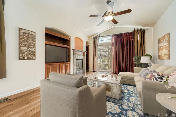 a view of a livingroom with wooden floor ceiling fan and window