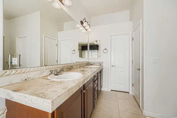 an empty room with a chandelier fan and windows