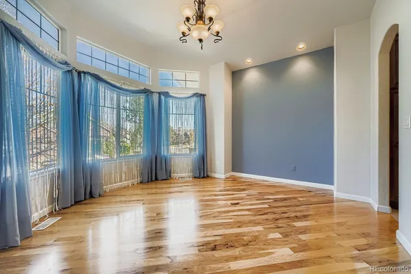 a view of a livingroom with wooden floor and a ceiling fan