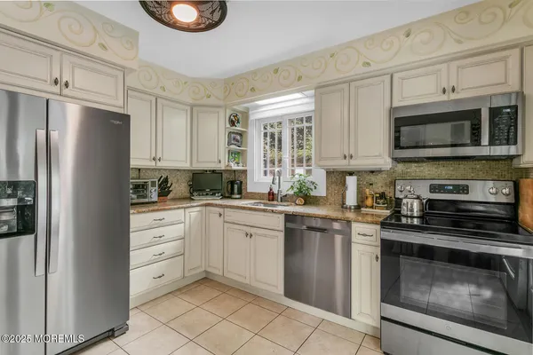 a kitchen with stainless steel appliances granite countertop a refrigerator and a stove top oven