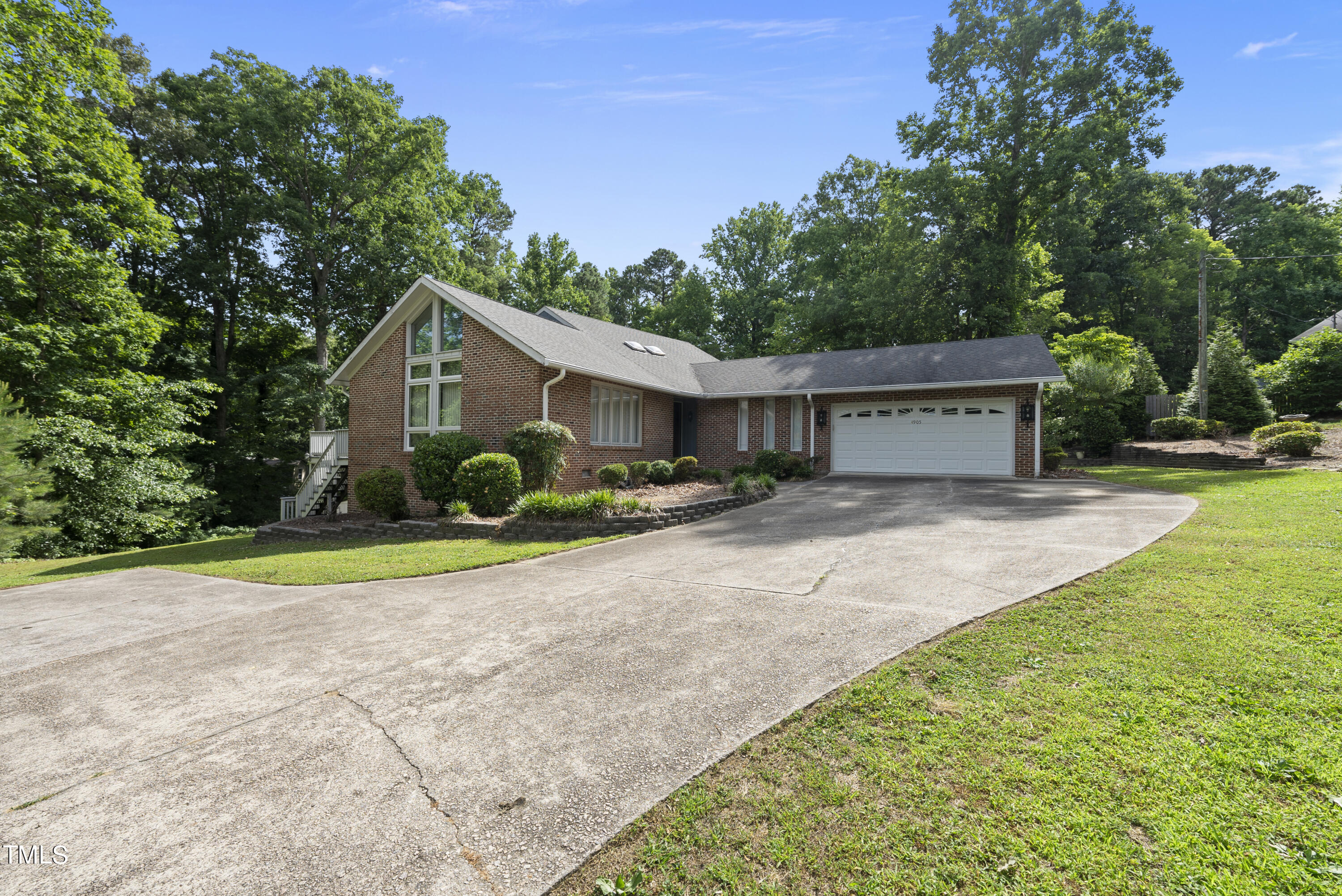 a view of a house with backyard and trees