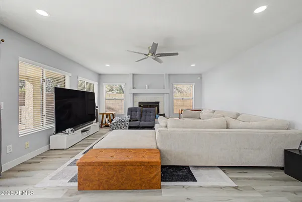 a living room with furniture a flat screen tv and a fireplace