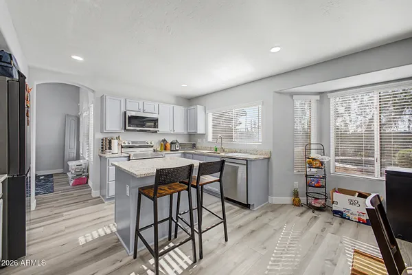 a kitchen with a table chairs refrigerator and cabinets