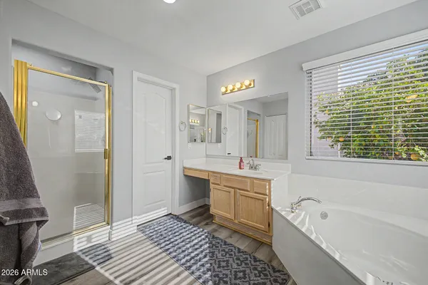 a bathroom with a tub a sink and a large mirror