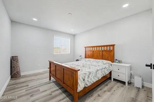 a bedroom with a bed and wooden floor