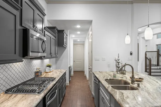 a kitchen with granite countertop a sink stove and cabinets