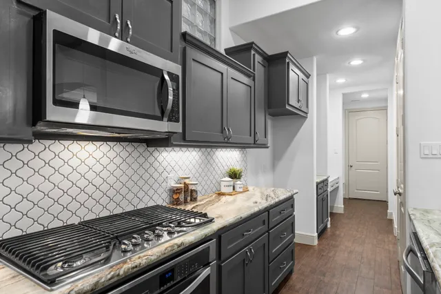 a kitchen with stainless steel appliances granite countertop a stove and a microwave
