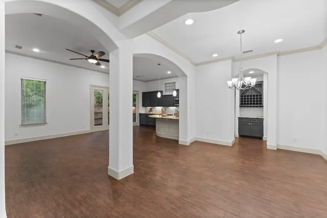 an empty room with kitchen and windows