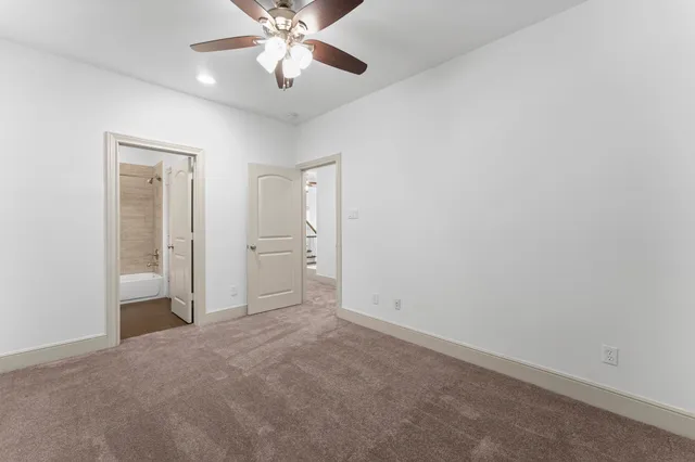 an empty room with closet and a chandelier fan