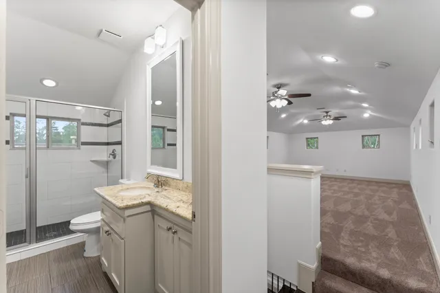 a bathroom with a sink a toilet and shower