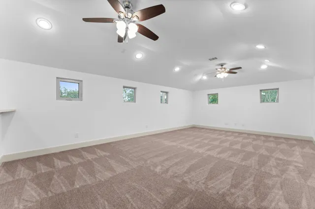 an empty room with fan and windows