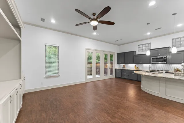 a living room with stainless steel appliances kitchen island granite countertop furniture and a large window