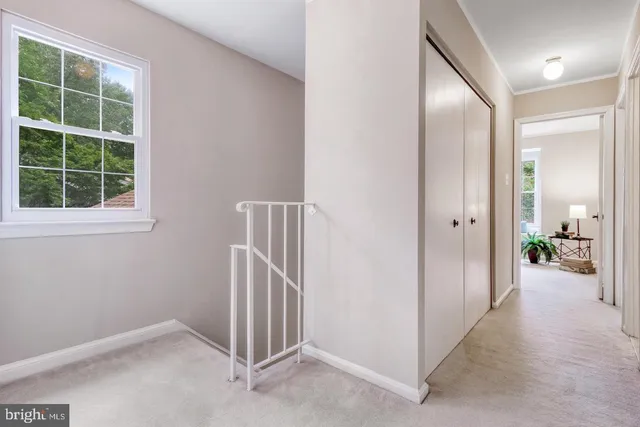 a view of a big room with windows and chandelier fan