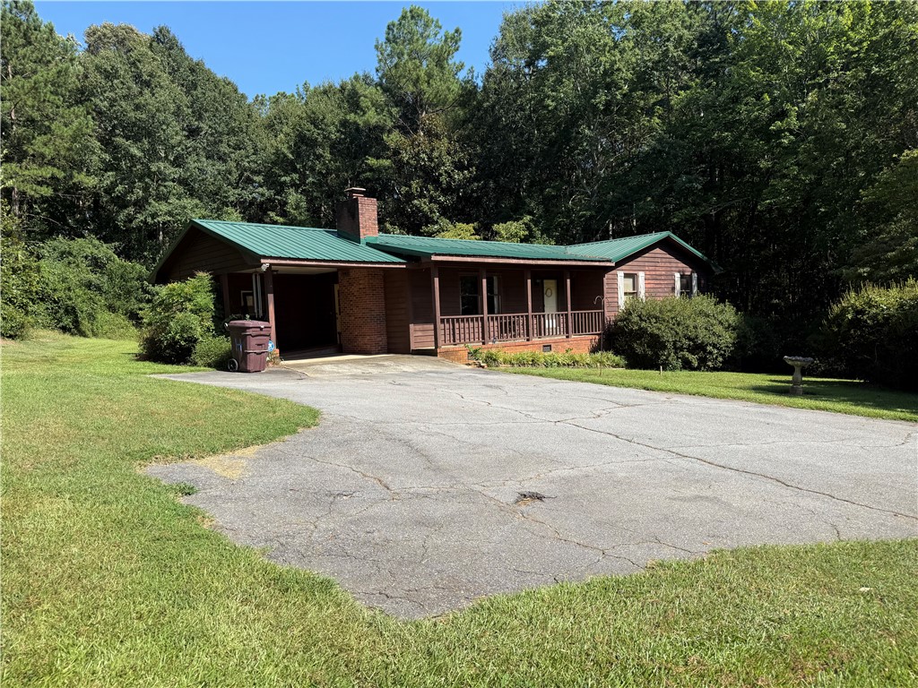 407 Seawright Drive Pendleton, SC 29670 - Photo 4 of 29 A classic metal roof and welcoming front porch highlight this charming woodland retreat.
