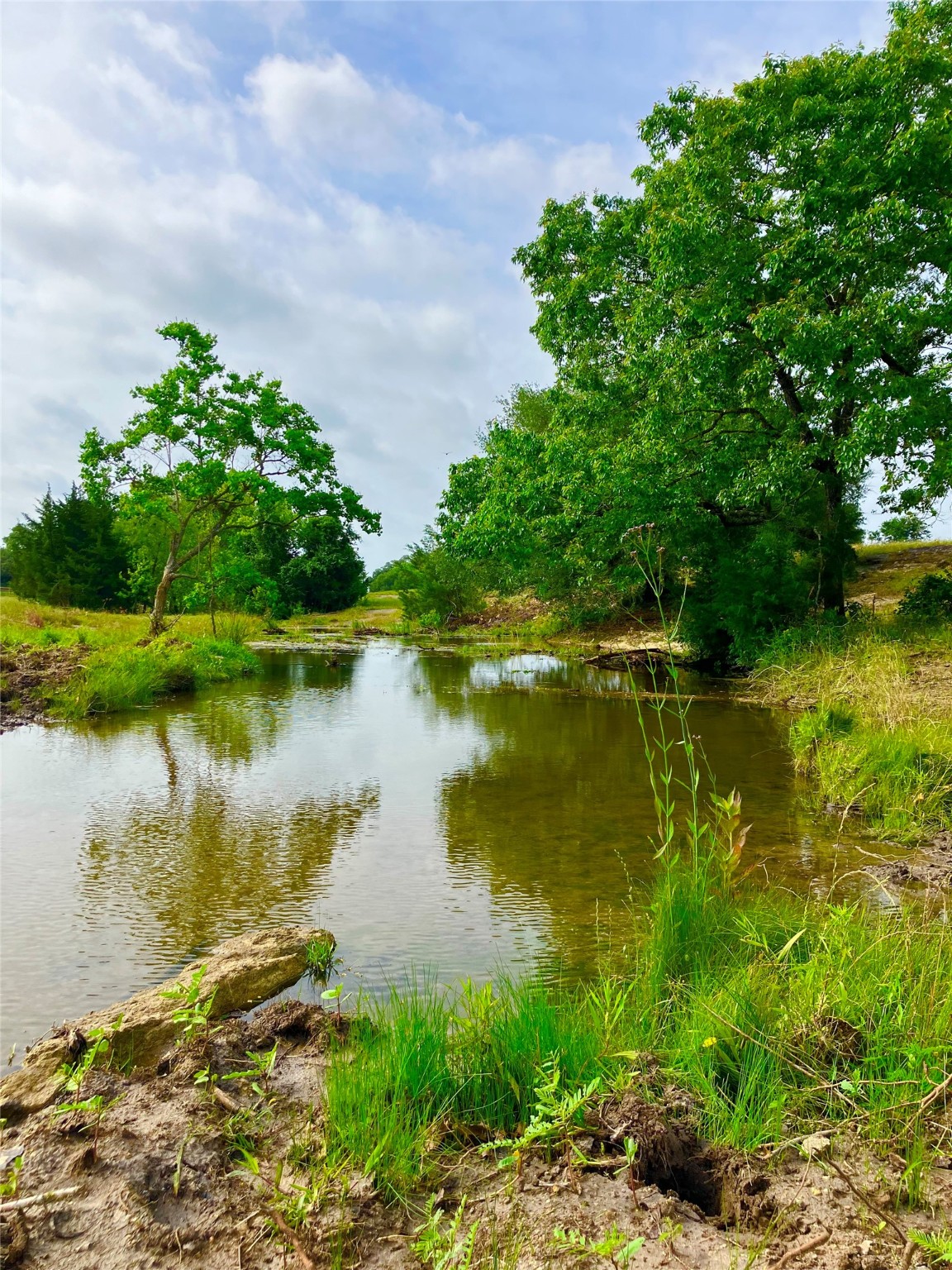 7009 Sandy Hill Road Brenham, TX 77833 - Photo 28 of 41 a view of a lake with a building in front of it