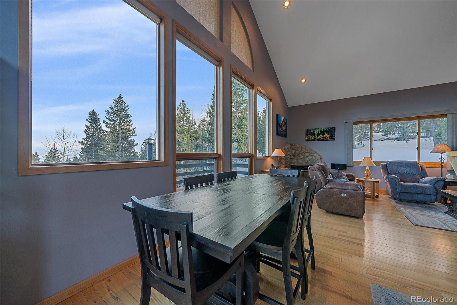 11222 Conifer Mountain Road Conifer, CO 80433 - Photo 13 of 49 a view of a dining room with furniture window and wooden floor