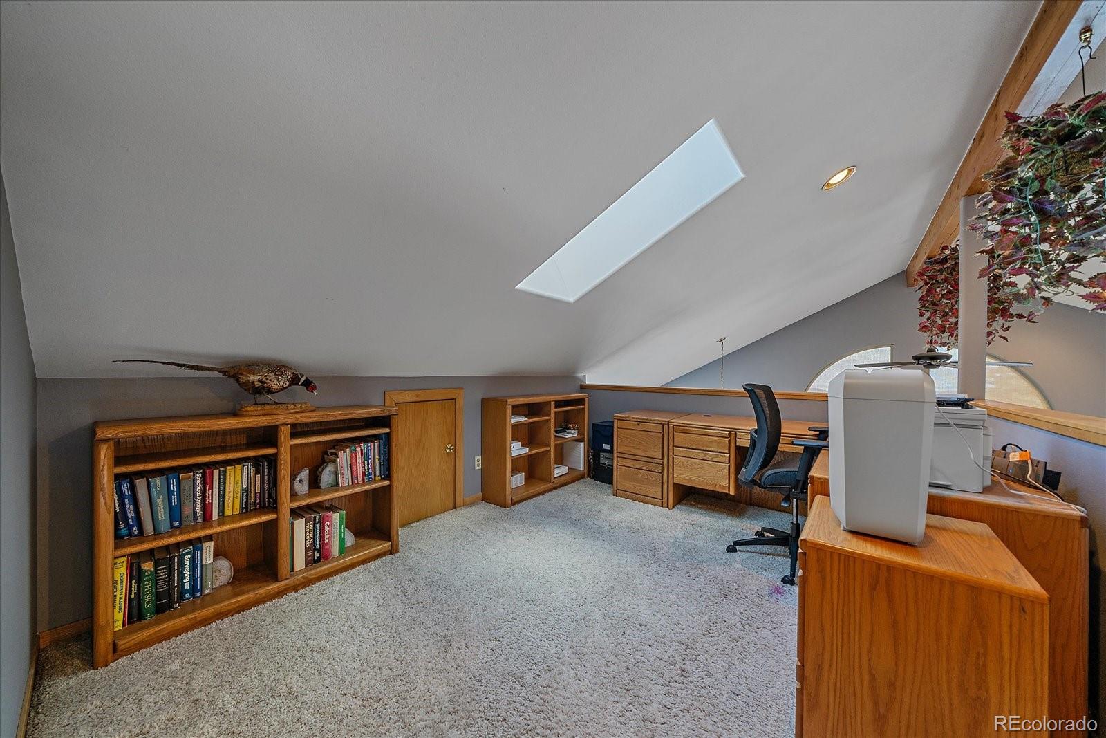 11222 Conifer Mountain Road Conifer, CO 80433 - Photo 24 of 49 a room with furniture and a book shelf