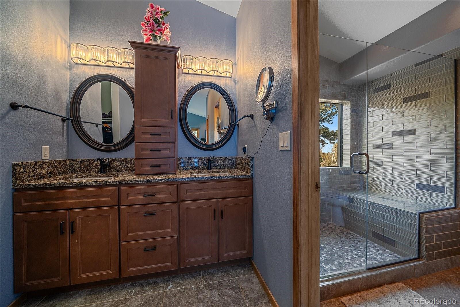 11222 Conifer Mountain Road Conifer, CO 80433 - Photo 29 of 49 a bathroom with a granite countertop double vanity sink and a mirror