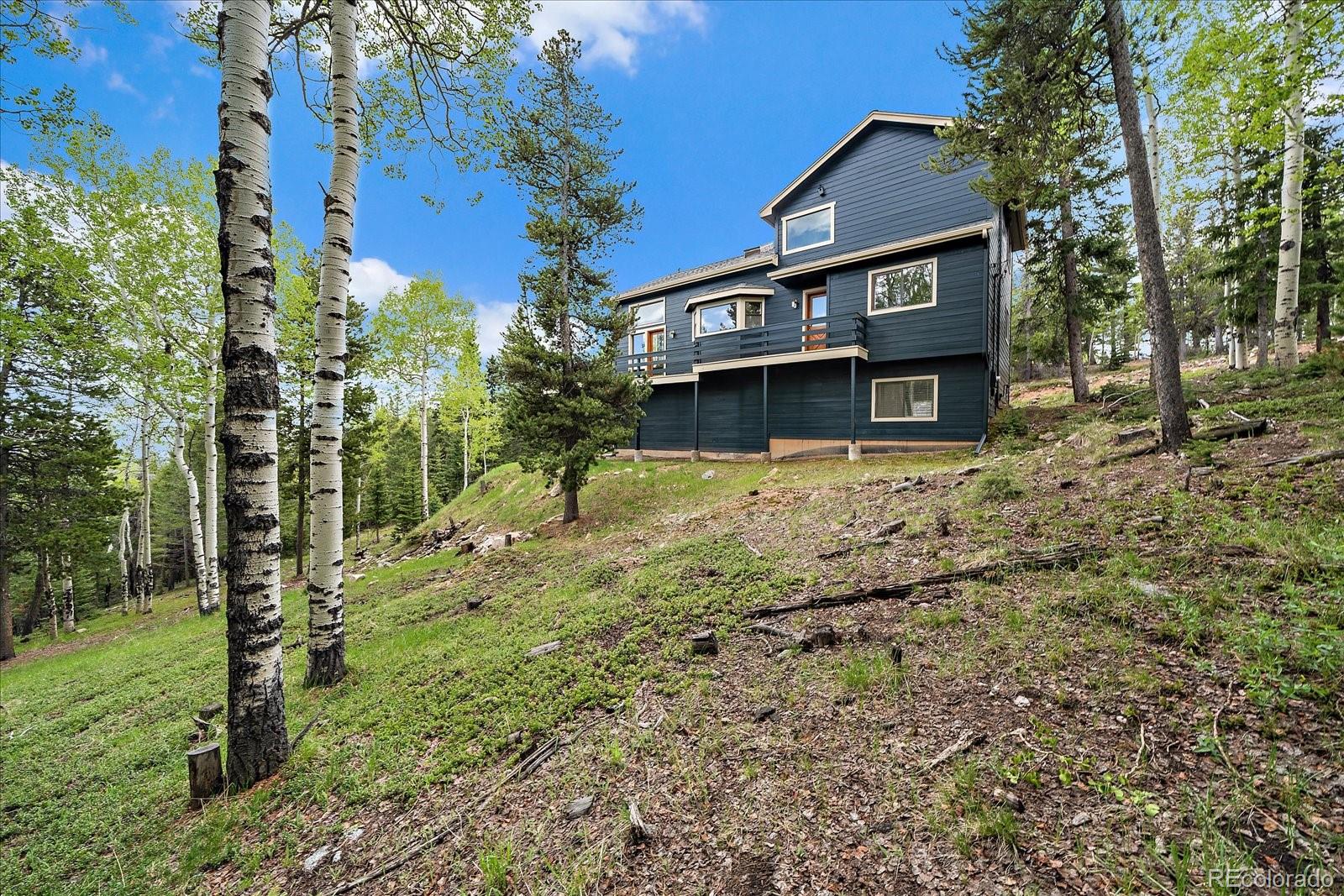 11222 Conifer Mountain Road Conifer, CO 80433 - Photo 38 of 49 a front view of a house with a yard