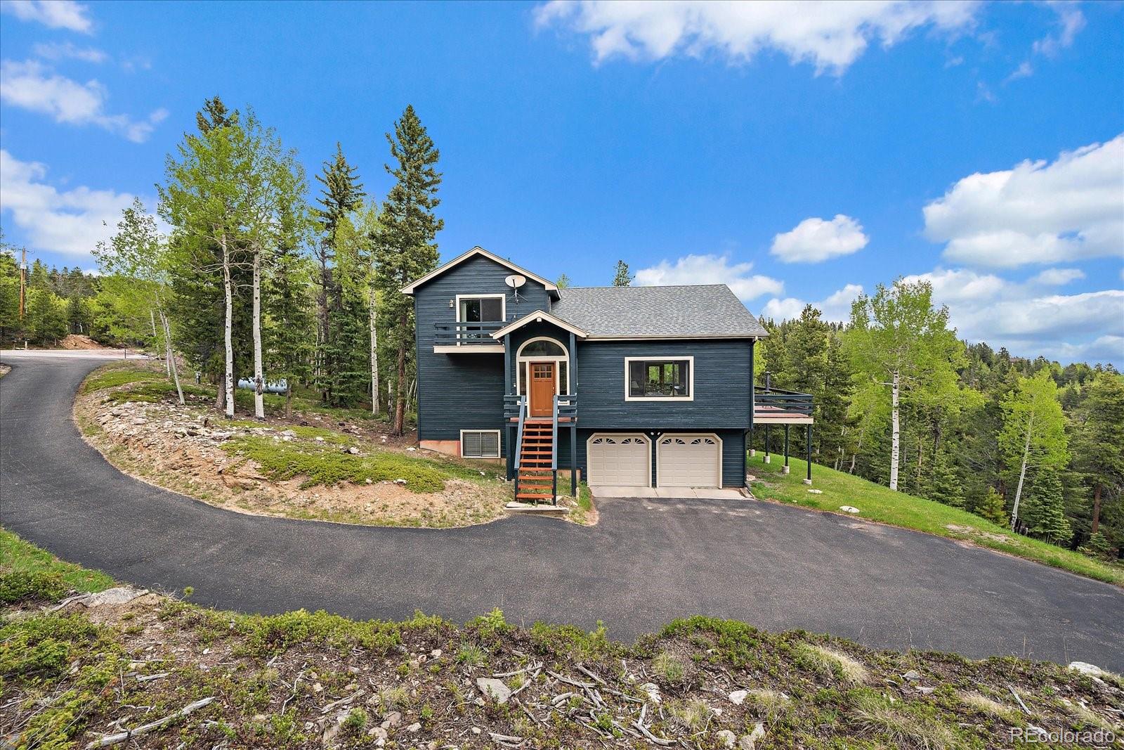 11222 Conifer Mountain Road Conifer, CO 80433 - Photo 40 of 49 a front view of a house with a yard