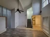 a view of a hallway with wooden floor and a ceiling fan
