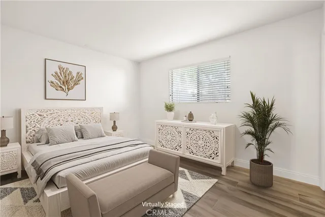 a spacious bedroom with a large bed and a potted plant