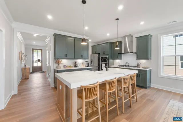 a large kitchen with kitchen island a sink table and chairs