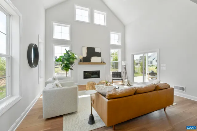 a living room with furniture a fireplace and a large window