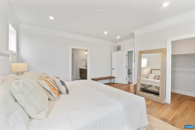 a spacious bedroom with a bed and a large mirror