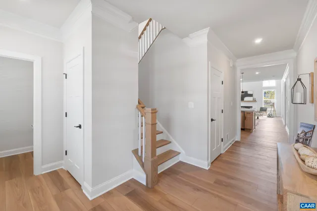 a view of a hallway with wooden floor and staircase