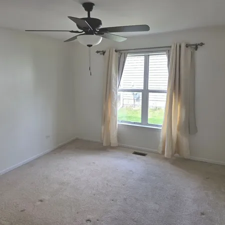 a view of empty room with ceiling fan