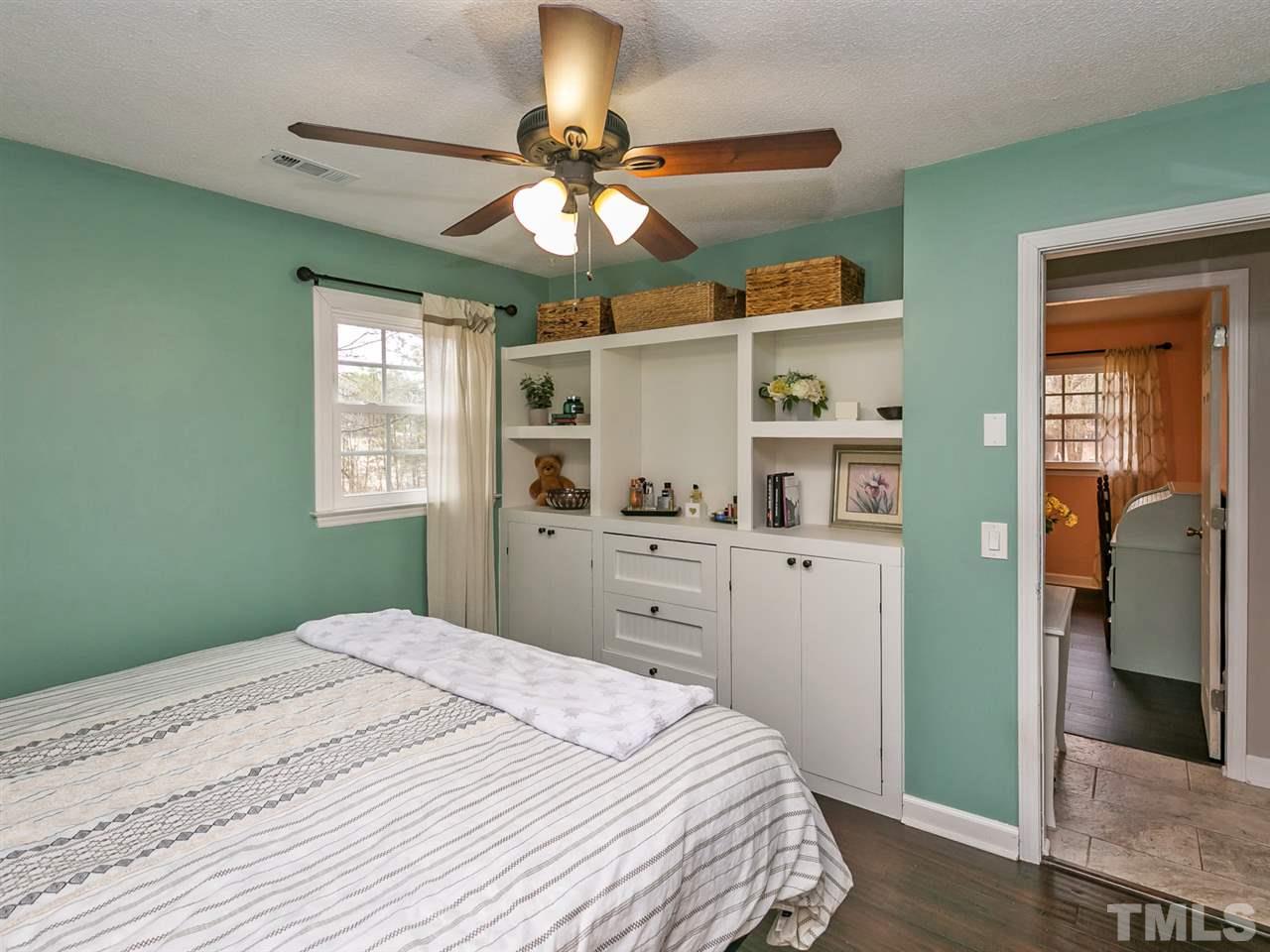 7532 Martin Road Zebulon, NC 27597 - Photo 13 of 26 a bedroom with a bed and a chandelier