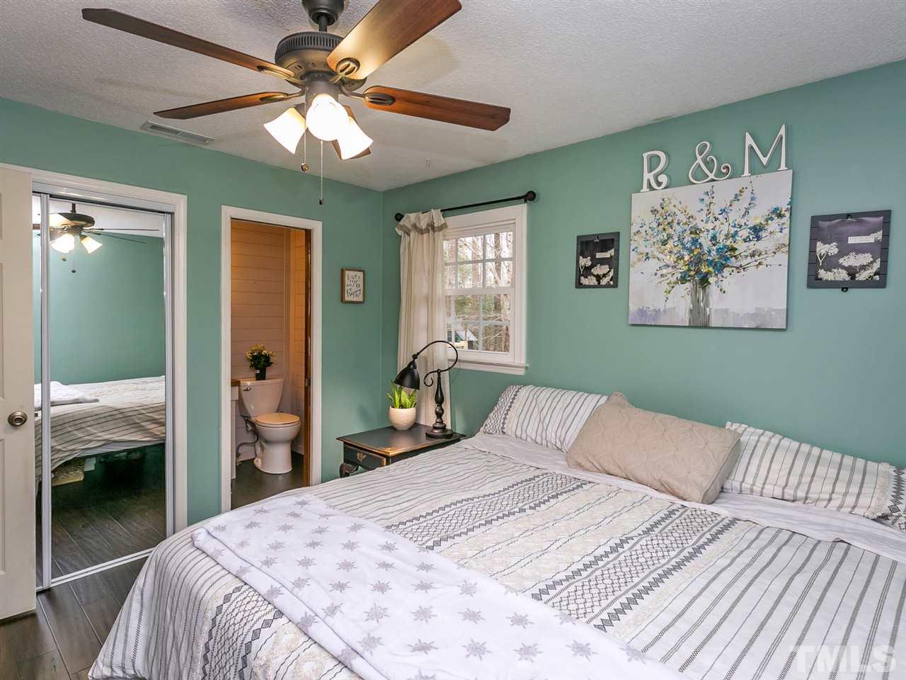 7532 Martin Road Zebulon, NC 27597 - Photo 14 of 26 a bedroom with a bed and a chandelier