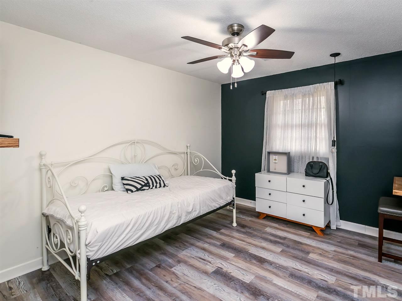 7532 Martin Road Zebulon, NC 27597 - Photo 17 of 26 a bedroom with a bed and a chandelier