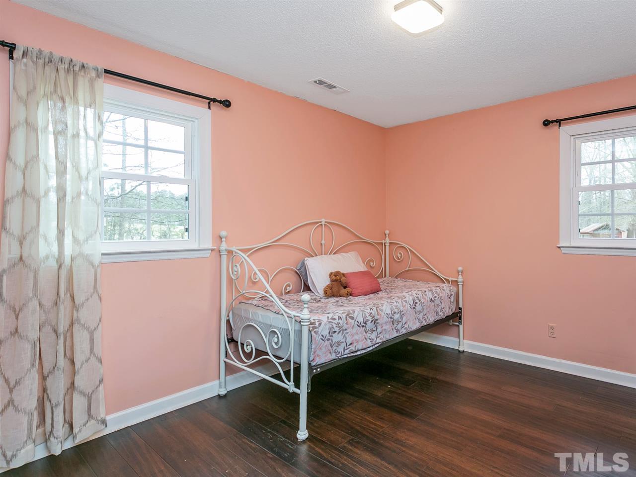 7532 Martin Road Zebulon, NC 27597 - Photo 18 of 26 a bed room with a bed window and a mirror