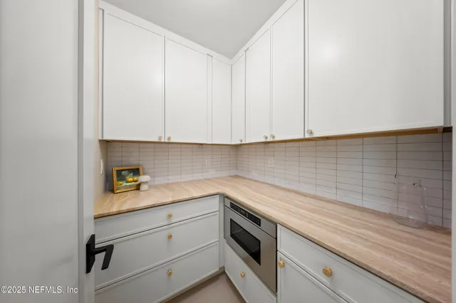 a kitchen with white cabinets and sink