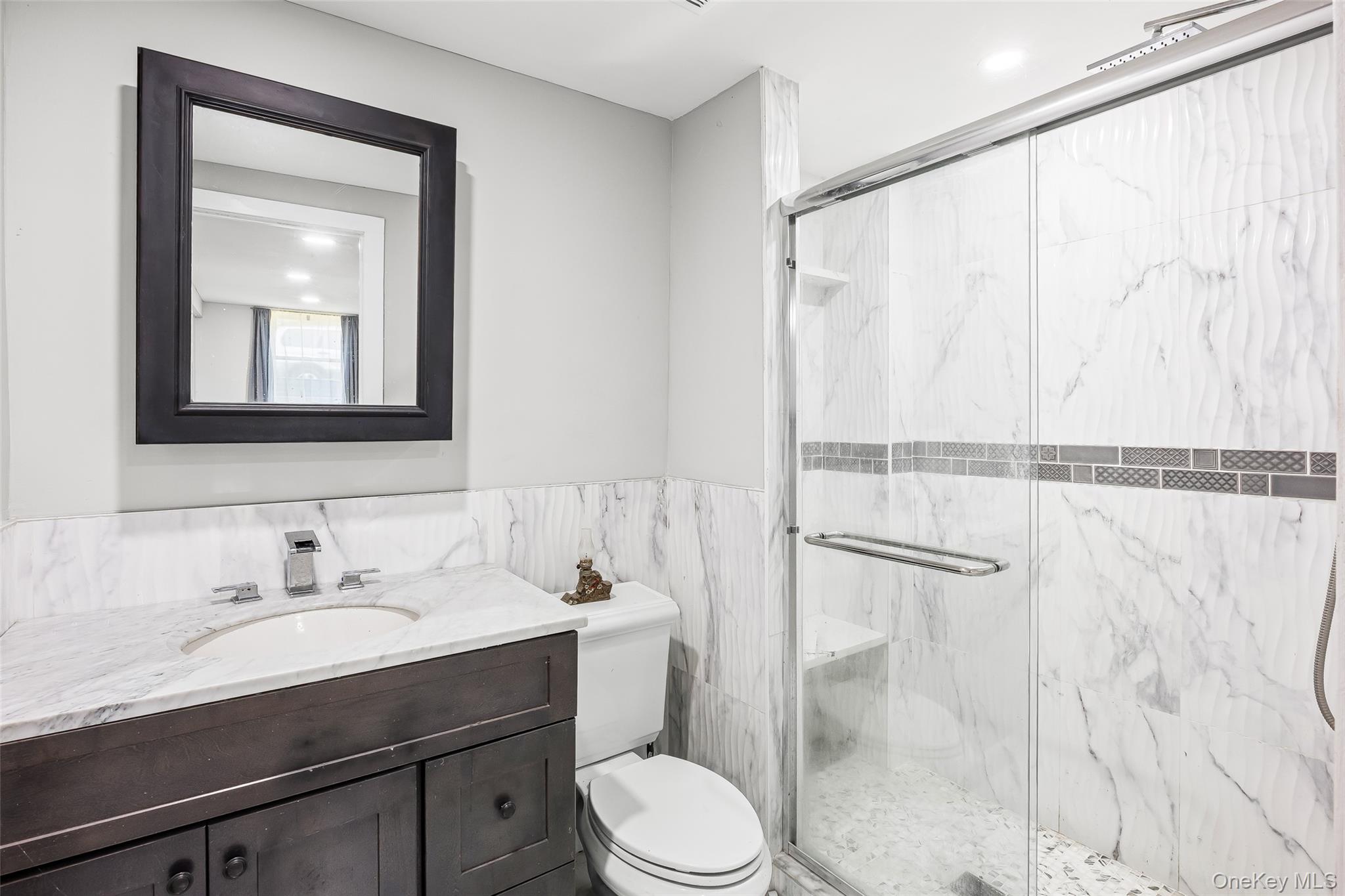 143 Rocky Point Landing Road Rocky Point, NY 11778 - Photo 24 of 43 a bathroom with a sink vanity mirror and toilet