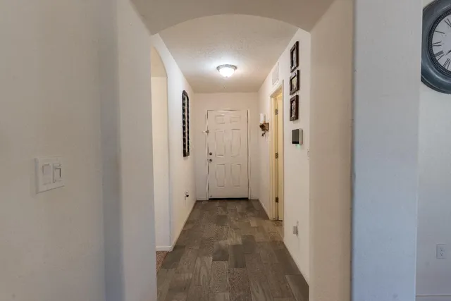 a view of a hallway with wooden floor and a bathroom