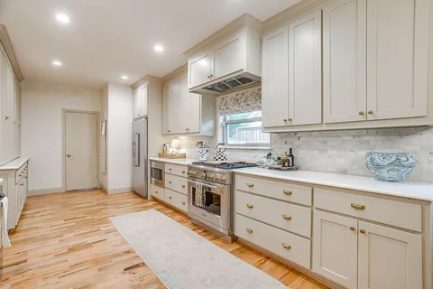 a kitchen with granite countertop white cabinets stainless steel appliances and sink