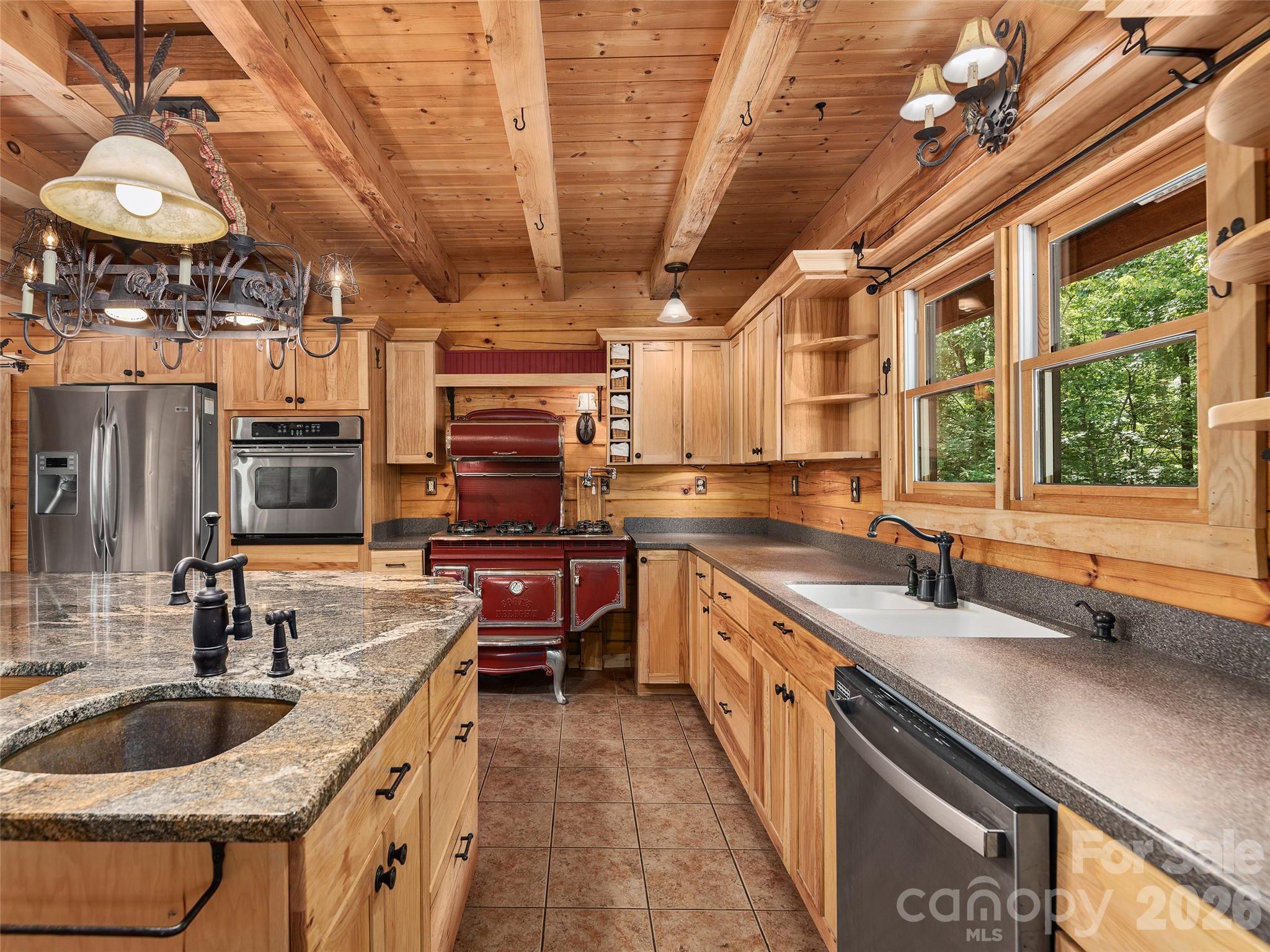 413 Green Hills Road Mill Spring, NC 28756 - Photo 15 of 48 a kitchen with stainless steel appliances granite countertop a sink a stove and a wooden cabinets