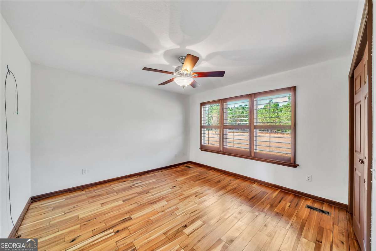 11157 Cannonville Road Rochelle, GA 31079 - Photo 13 of 38 a view of an empty room with wooden floor and a window