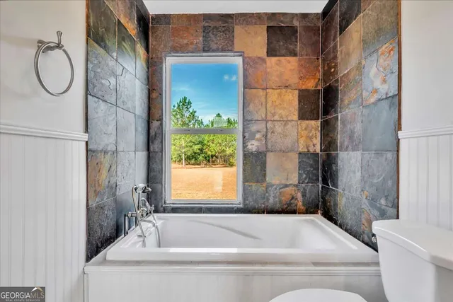 a bathroom with a granite countertop bathtub and sink